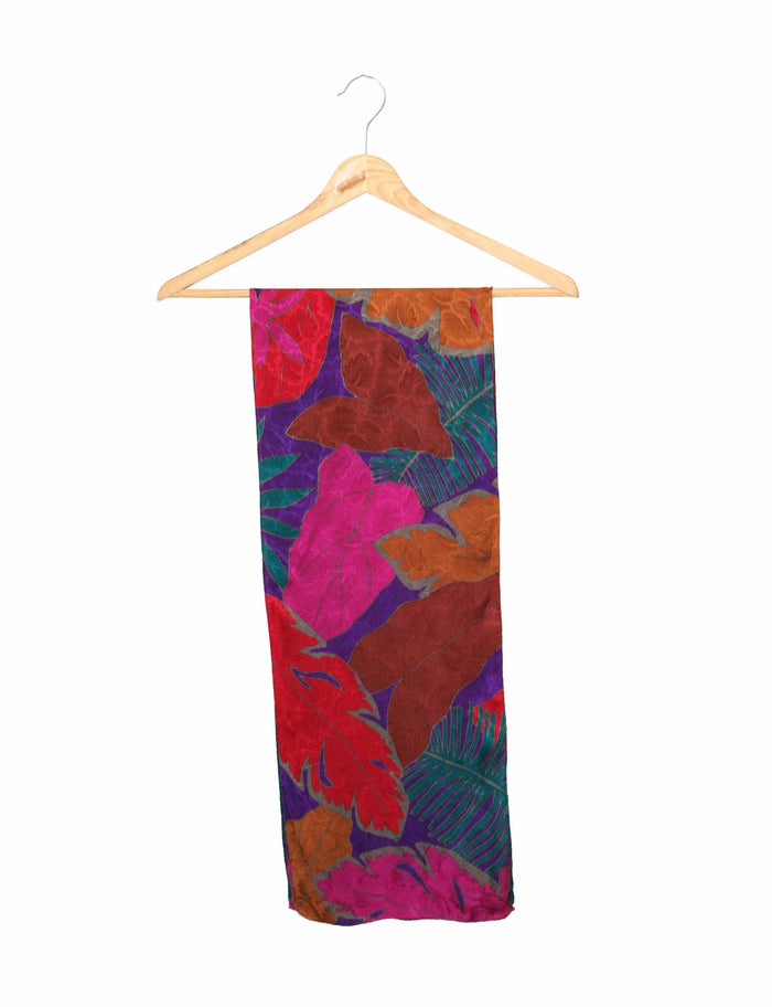 Long silk scarf with floral leaves pattern in magenta, teal, orange, and purple.